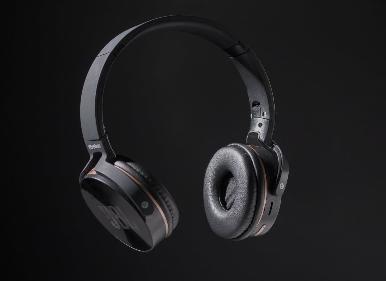 Close-up of wireless headphones on a dark background, showcasing design and texture.